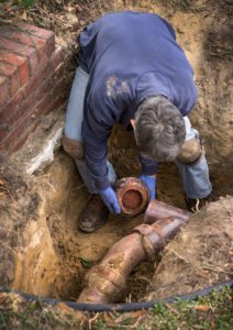 man digging to replace plumbing pipes